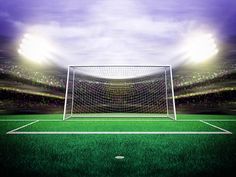 a soccer goal in front of an empty field with bright lights on the stadium's stands