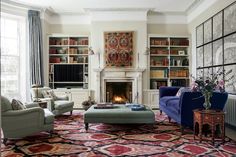 a living room filled with furniture and a fire place in the middle of a room