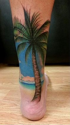 a man's leg with a palm tree tattoo on it