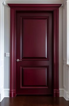 an empty room with a red door and white walls