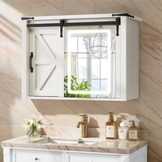 a bathroom with a sink, mirror and white cabinet in it's center area