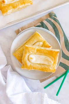 two slices of banana cream pie on a white plate next to a green and yellow napkin