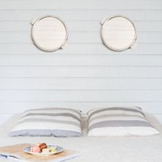 a bed with two round mirrors above it