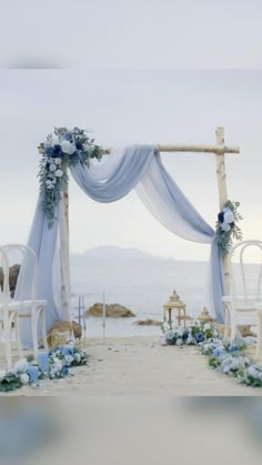 an outdoor wedding ceremony setup with blue flowers and white draping on the arch