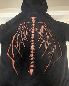 the back of a black hoodie with an orange dragon on it