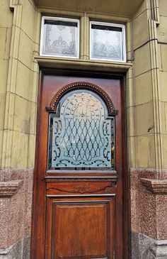 a wooden door with two windows above it