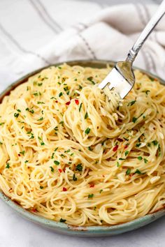 a fork is being used to eat spaghetti in a bowl