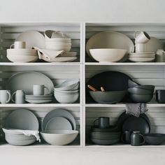 the shelves are filled with dishes and plates