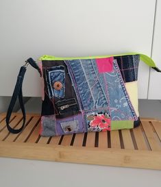 a multicolored patchwork purse sitting on top of a wooden shelf next to a white wall