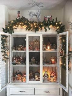 a white china cabinet filled with christmas decorations