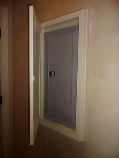 an open door in the corner of a room that is being painted tan and white