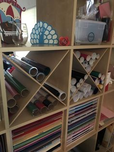 the shelves are filled with different types of crafting supplies and paper rolls on them