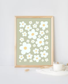 a frame with flowers on it next to a candle