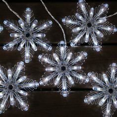 snowflake lights are hanging on a wooden surface