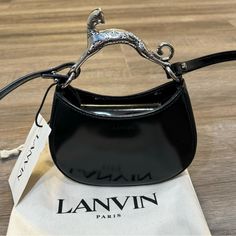 Lanvin Nano Hobo Cat Top Handle Crossbody Black Handbag Nwt Msrp $1995 Unisex Brand New Never Worn With Tags And Dust Bag Sold Out Online Embellished With A Sculptural Cat Handle, This Hobo Bag With Soft And Elegant Lines Can Be Carried In The Hand Or Over The Shoulder. Details Nano Hobo Cat Bag In Black Leather Color: Black Made In Italy Size And Fit L X H X W: 15.5 X 11 X 3.5 Cm (6.1 X 4.3 X 1.4 In.) Carry In The Hand Or Wear On The Shoulder With The Strap Adjustable Shoulder Strap With Buckle Lanvin Hobo Cat Bag, Chic Top Handle Bag With Silver-tone Logo Plaque, Modern Party Bags With Silver-tone Logo Plaque, Chic Evening Bag With Silver-tone Logo Plaque, Lanvin Bag, Black Handbag, Cat Bag, Cat Top, Brass Material