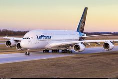 a large jetliner sitting on top of an airport tarmac at sunset or dawn