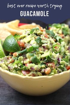 guacamole in a yellow bowl with limes on the side