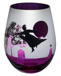 a purple and white wine glass with a silhouette of a woman holding a cross