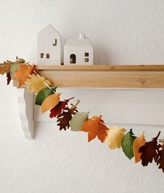 an autumn garland with leaves and houses on it