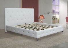 a white bed sitting on top of a carpeted floor