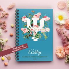 a personalized notebook with flowers on the front and bottom, surrounded by other flowers