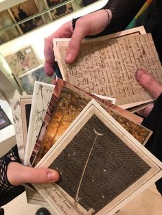 a person holding up several old photos in their hands, some with writing on them