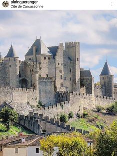 the castle is built on top of a hill with trees around it and surrounded by buildings