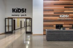 the entrance to a children's nursery store with wooden walls and black doors on both sides