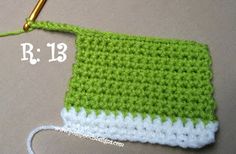 a crocheted green and white bag sitting on top of a table next to a pair of scissors