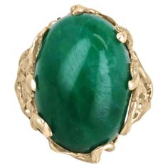 This impressive solitaire ring features a stunning centerpiece in the form of a huge 19-carat oval cabochon cut emerald from Colombia, prized for producing some of the world's most beautiful emeralds. The emerald displays a rich, dark green color that is truly captivating. The emerald is securely set in a unique 14k gold nugget style setting, with nugget prongs that add to the rugged, organic feel of the design. The result is a striking and unforgettable piece of jewelry that is sure to turn hea Elegant Cabochon Emerald Ring, Elegant Emerald Ring With Cabochon Cut, Elegant Emerald Cabochon Ring, Luxury Emerald Ring With Oval Cabochon, Oval Cabochon Emerald Ring For May Birthstone, Elegant Cabochon Emerald Ring For Formal Occasions, Oval Cabochon Emerald Ring Gift, Elegant Green Cabochon Emerald Ring, Elegant Green Emerald Cabochon Ring