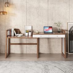 a desk with a laptop, books and other items on it in front of a wall