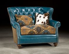 a blue leather chair with decorative pillows on it's back and armrests