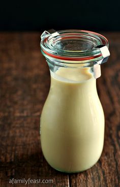 a glass bottle filled with milk sitting on top of a wooden table