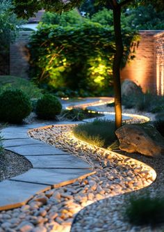 a stone path lit up by lights in the evening