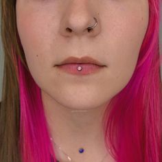 a woman with pink hair and piercings on her nose