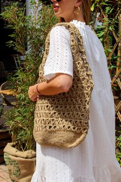 a woman carrying a crocheted bag on her back