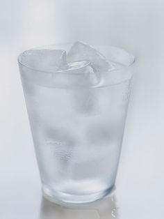 a glass filled with ice sitting on top of a table