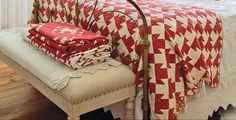 a bed with red and white quilts on it