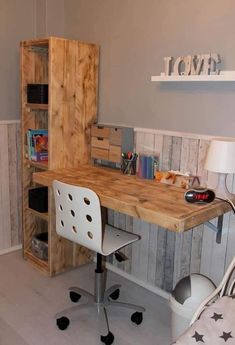 a room with a desk, chair and bookshelf on the wall next to it