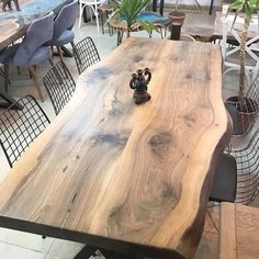 a large wooden table sitting in the middle of a room filled with chairs and tables