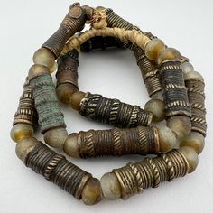 A strand of Old African TIV Bronze trade beads - late 1800's to early 1900's. Nicely worn old beads with a rich patina.  Traditionally worn in the hair Separated by traditional recycled glass beads. 14 Tiv beads  29" of beads 32" length 14 to 20mm diameter 35 to 48mm long 8-9mm hole Vintage Bronze Beaded Necklaces With Large Beads, Vintage Bronze Beaded Necklace With Large Beads, Vintage Style Wooden Beads For Jewelry Making, Antique Round Spacer Beads, Vintage Bronze Beaded Necklaces With Round Beads, Vintage Hand-strung Beaded Necklace With Round Beads, Vintage Wooden Round Beads, Artisan Bronze Beaded Necklaces With Large Beads, Bronze Artisan Beaded Necklace With Large Beads