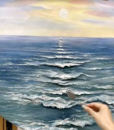 someone is painting an ocean scene with waves