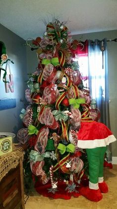 a christmas tree decorated with lollipops, candy canes and santa hat