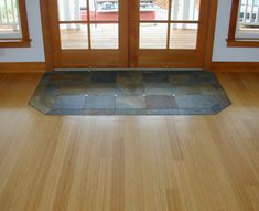 an empty room with wood floors and glass doors that lead to the front porch area