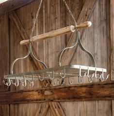 a wooden and metal chandelier hanging from a ceiling in a barn with wood paneling