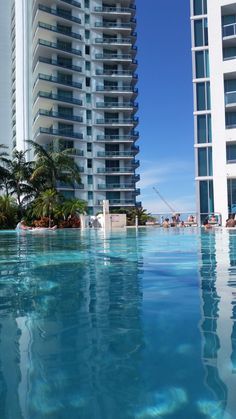 an empty swimming pool with buildings in the background