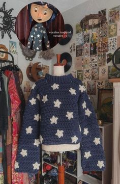 a crocheted sweater with stars on it is hanging in front of a mirror