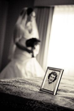 a bride and her mother are in the background with an old photo on the bed