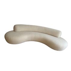 two white pillows sitting next to each other on top of a white surface and one is shaped like a curved object