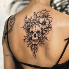 a woman with a skull and flowers tattoo on her back